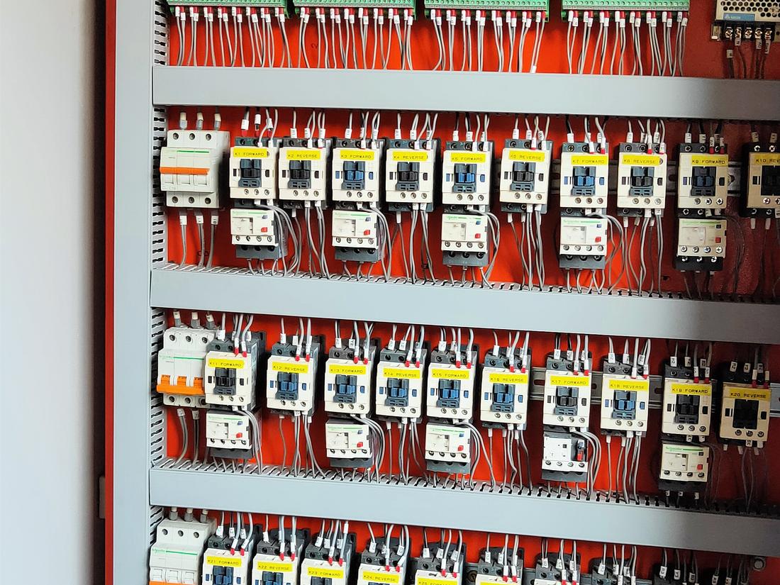 Close-up of ferruled wiring with contactors labelled forward and reverse